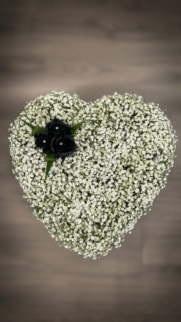 White funeral heart tribute with dark roses, Eastbourne