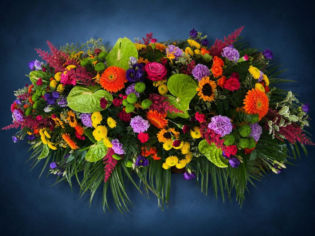 Colourful casket spray funeral flowers, Eastbourne